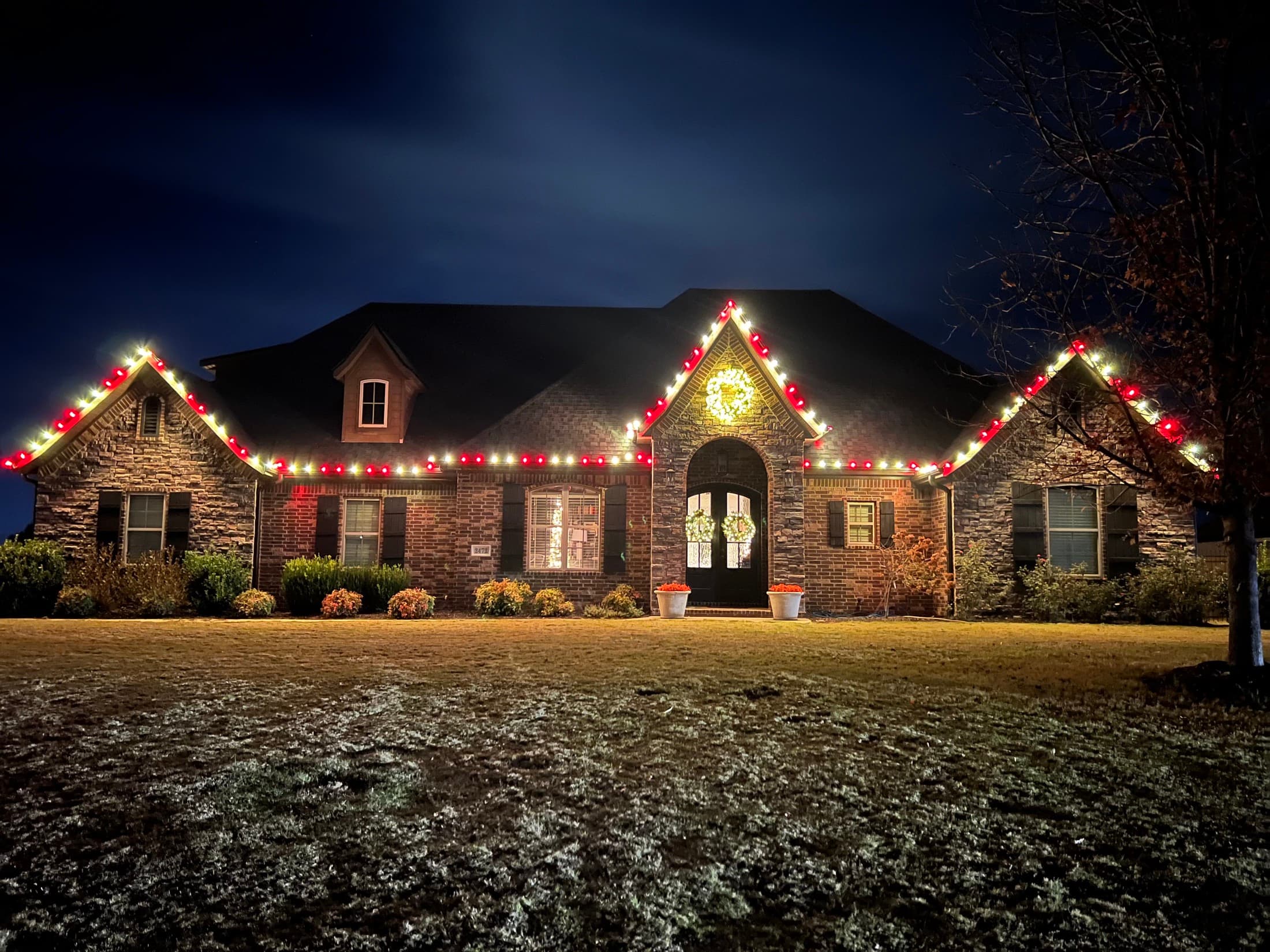A Boss Hog red and warm-white roofline installation on a Northwest Arkansas home